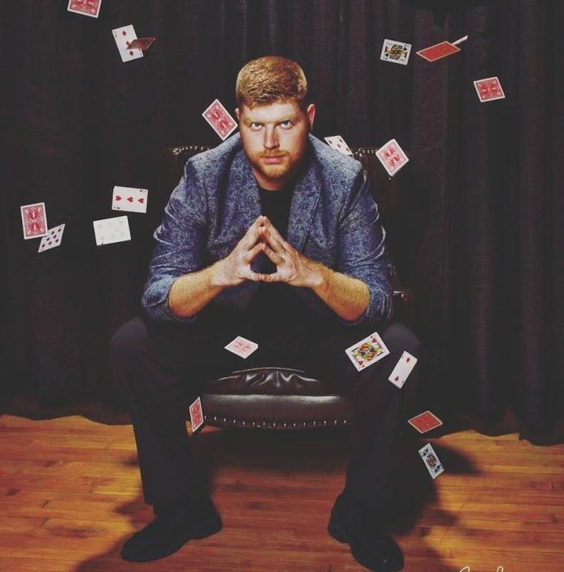 Dan Luckett in a chair in front of cards