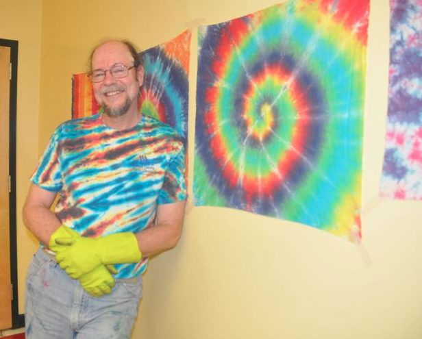 cliff the tie dye guy in front of tie dye wall hanging